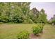 This backyard offers lush green lawn bordered by shade trees and manicured shrubs at 130 Scotch Broom Dr. # H-103, Little River, SC 29566