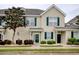 Charming townhome with tan siding, dark green shutters, and landscaped front with manicured bushes and a decorative tree at 130 Scotch Broom Dr. # H-103, Little River, SC 29566