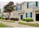 Inviting townhome features tan siding, dark green shutters, a walkway, and landscaped front with decorative trees and shrubs at 130 Scotch Broom Dr. # H-103, Little River, SC 29566