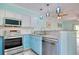 Modern kitchen with stainless steel appliances, pendant lighting, granite counters, and white and blue cabinetry at 130 Scotch Broom Dr. # H-103, Little River, SC 29566