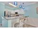Bright kitchen featuring granite countertops, stainless steel appliances, bar seating, and white and blue cabinetry at 130 Scotch Broom Dr. # H-103, Little River, SC 29566
