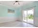 Bright living room features neutral flooring, wainscoting, beach-themed art and sliding doors to a patio at 130 Scotch Broom Dr. # H-103, Little River, SC 29566