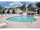 Community pool featuring a pool, several lounge chairs, and a cabana for relaxation on a partly cloudy day at 130 Scotch Broom Dr. # H-103, Little River, SC 29566