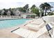 Community pool surrounded by lounge chairs, manicured grounds, shaded cabana, and white picket fence at 130 Scotch Broom Dr. # H-103, Little River, SC 29566