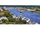 Striking aerial view of a coastal waterway featuring a lighthouse surrounded by homes and lush greenery at 1301 Bay View Ct., North Myrtle Beach, SC 29582