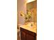 Well-lit bathroom with a white marble countertop, dark wooden vanity, and decorative floral arrangements at 1308 Riverport Dr., Conway, SC 29526