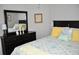 Bedroom featuring a wooden dresser with mirror, patterned bedding, and bright yellow pillows at 1308 Riverport Dr., Conway, SC 29526