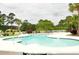 Large community pool surrounded by lush greenery and lounge chairs, perfect for summer relaxation at 1308 Riverport Dr., Conway, SC 29526