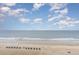 Expansive view of the beach with blue umbrellas scattered on the golden sands at 1501 S Ocean Blvd. # 1044, Myrtle Beach, SC 29577