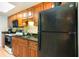 This condo features a kitchen with granite counters, a black microwave, wood cabinets, and a black refrigerator at 1501 S Ocean Blvd. # 1044, Myrtle Beach, SC 29577