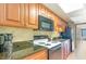 Efficient kitchen with wood cabinets, granite counters, a black microwave, and a white cooktop at 1501 S Ocean Blvd. # 1044, Myrtle Beach, SC 29577