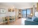 The unit has a well furnished living room with a TV, sliding glass doors to the balcony, and a dining table at 1501 S Ocean Blvd. # 1044, Myrtle Beach, SC 29577