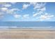 Serene beach view showcasing the sandy shoreline and calm ocean waters under a clear sky at 1501 S Ocean Blvd. # 842, Myrtle Beach, SC 29577