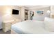 Bedroom featuring a television, dresser and view into kitchen area at 1501 S Ocean Blvd. # 842, Myrtle Beach, SC 29577