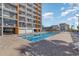 Relaxing outdoor pool area with lounge chairs next to an impressive condo building featuring private balconies at 1501 S Ocean Blvd. # 842, Myrtle Beach, SC 29577