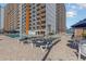 Outdoor pool and sunbathing area with lounge chairs outside a large condo building with private balconies at 1501 S Ocean Blvd. # 842, Myrtle Beach, SC 29577