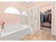 Bathroom featuring a tub, glass shower, linen closet and walk-in closet at 1504 Sedgefield Dr., Murrells Inlet, SC 29576