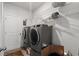 The laundry room boasts modern washer and dryer units, with shelving, a basket, and lighting at 155 Marsh Deer Place, Surfside Beach, SC 29575