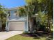 Charming two-story home with a well-maintained yard and palm trees, showcasing its inviting curb appeal at 18 Trigger Fish Ln., Murrells Inlet, SC 29576