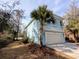Bright blue two-story home with palm trees, a well-kept lawn, and an attached garage at 18 Trigger Fish Ln., Murrells Inlet, SC 29576