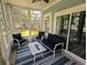 Comfortable screened porch with a blue rug, ceiling fan, and outdoor seating at 18 Trigger Fish Ln., Murrells Inlet, SC 29576