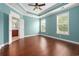 Primary bedroom featuring tray ceilings, hardwood floors, and natural light at 1881 Willowcress Ln., Myrtle Beach, SC 29577