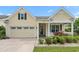 Charming home with a two-car garage, yellow siding, a porch and a beautifully landscaped front yard at 1881 Willowcress Ln., Myrtle Beach, SC 29577