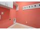 Laundry room featuring storage and white cabinets with coral colored walls at 1881 Willowcress Ln., Myrtle Beach, SC 29577
