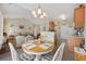 Bright dining area with a round table, chandelier, and open concept design leading to the living room at 195 Cupola Dr., Longs, SC 29568