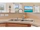 Close-up of kitchen sink with modern faucet, neutral countertops, and a view to the outdoor patio at 195 Cupola Dr., Longs, SC 29568