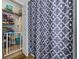 Bathroom view showcasing closet with shelving and gray patterned shower curtain at 2090 Cross Gate Blvd. # 202, Surfside Beach, SC 29575