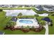 Aerial view of a pristine community pool with lounge chairs, umbrellas and a serene pond surrounded by lush greenery at 2090 Cross Gate Blvd. # 202, Surfside Beach, SC 29575