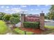 Elegant brick community entrance sign for Maddington Place, adorned with lush landscaping and manicured shrubs at 2090 Cross Gate Blvd. # 202, Surfside Beach, SC 29575