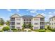 Attractive condo building featuring covered balconies and manicured landscaping at 2090 Cross Gate Blvd. # 202, Surfside Beach, SC 29575