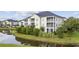 Beautiful exterior view of a condo building with pond, landscaping and screened-in porches at 2090 Cross Gate Blvd. # 202, Surfside Beach, SC 29575