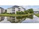 Scenic view of condo building reflected in a pond, surrounded by lush greenery at 2090 Cross Gate Blvd. # 202, Surfside Beach, SC 29575