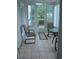 Cozy sun room with neutral tile flooring, glass table and door that leads to the outside at 22 Woodhaven Dr. # C, Murrells Inlet, SC 29576