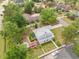 Aerial view showcasing the property's layout with a backyard patio, cottage, well-kept lawn, and surrounding trees at 221 Lander Dr., Conway, SC 29526