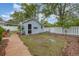Backyard featuring a cottage, stone pathway, and a well-maintained lawn bordered by a white picket fence at 221 Lander Dr., Conway, SC 29526