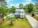 Charming two-story home with a well-manicured lawn, a driveway, a picket fence, and mature trees at 221 Lander Dr., Conway, SC 29526