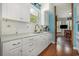 The kitchen has white cabinets, granite countertops, a stainless faucet, and wood-look tile flooring at 221 Lander Dr., Conway, SC 29526