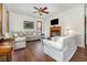 Cozy living room with a fireplace, comfortable sofas, hardwood floors, ceiling fan, and natural light at 221 Lander Dr., Conway, SC 29526
