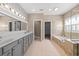Bright bathroom featuring a double vanity, a soaking tub, and an open doorway at 246 Laurel Bay Dr., Murrells Inlet, SC 29576