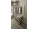 Bright bathroom featuring a vanity with a farmhouse sink, sleek mirror, shiplap accent wall, and storage at 25 Pinewood Dr., Carolina Shores, SC 28467
