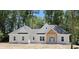 Charming, new construction, single-story home with a gray roof and a welcoming wooden-beam front entrance at 25 Pinewood Dr., Carolina Shores, SC 28467