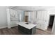 Kitchen with white cabinetry, a marble countertop, an island with a sink, and modern pendant lighting at 25 Pinewood Dr., Carolina Shores, SC 28467