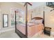 Cozy bedroom with four-poster bed, neutral walls, and a window with a view of outdoor foliage at 276 Waterfall Circle, Little River, SC 29566