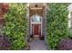 Inviting red front door framed by lush greenery and brick archway at 276 Waterfall Circle, Little River, SC 29566