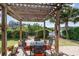 Charming pergola-covered patio with seating area overlooking a serene lake at 276 Waterfall Circle, Little River, SC 29566
