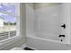 Bright and clean bathroom featuring a white tiled shower and bathtub, adjacent to a window at 2919 Hughes Gasque Rd., Aynor, SC 29511